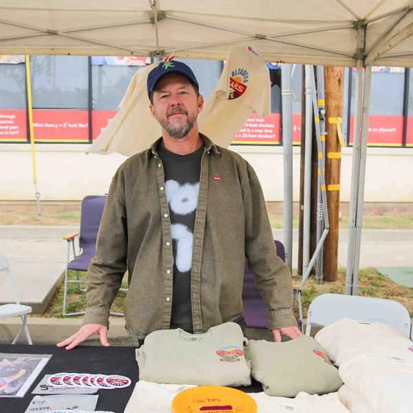 T-shirt vendor greeting visitors at his booth during Webster's 100th anniversary fair in Altadena