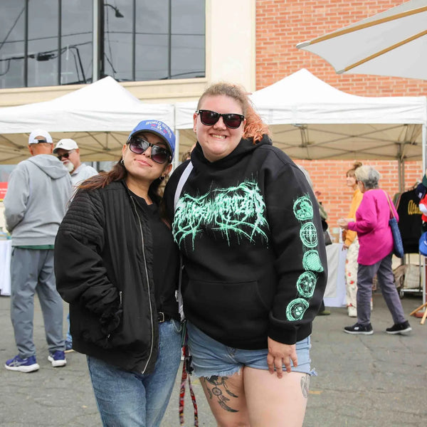 Two friends posing along the vendor row at Webster's anniversary celebration