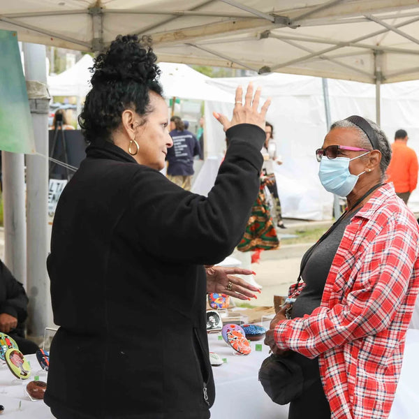 Vendors chatting with guests at their booth during Webster's anniversary fair
